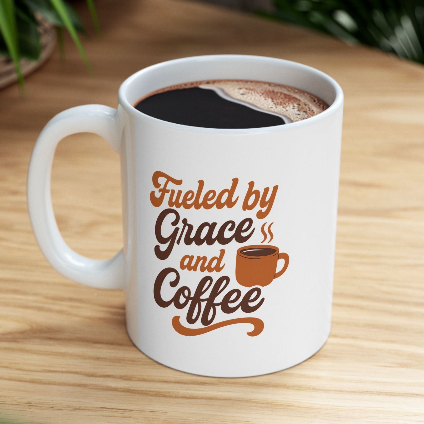 White mug with 'Fueled by Grace and Coffee' text on a wooden table