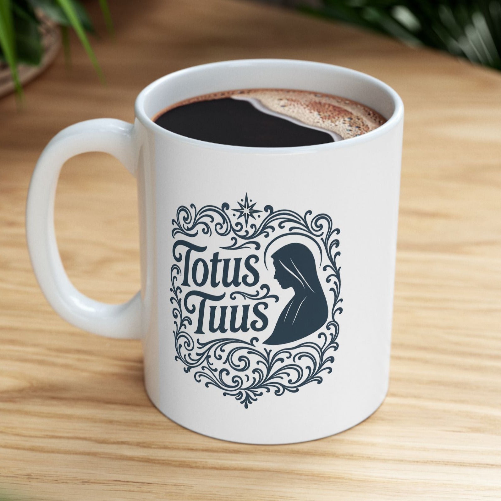 White mug with 'Totus Tuus' design on a wooden table